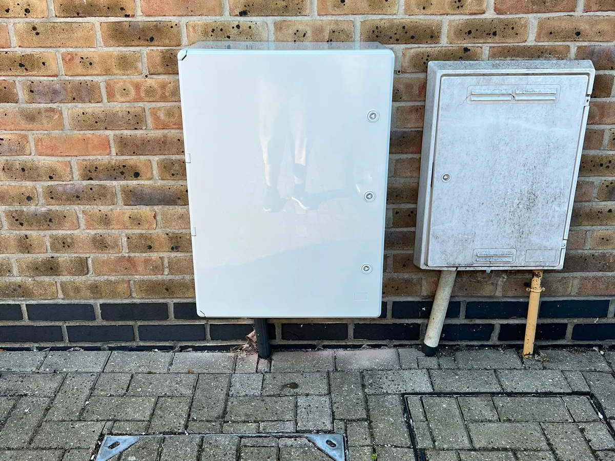 External electricity meter cabinet mounted on a brick wall