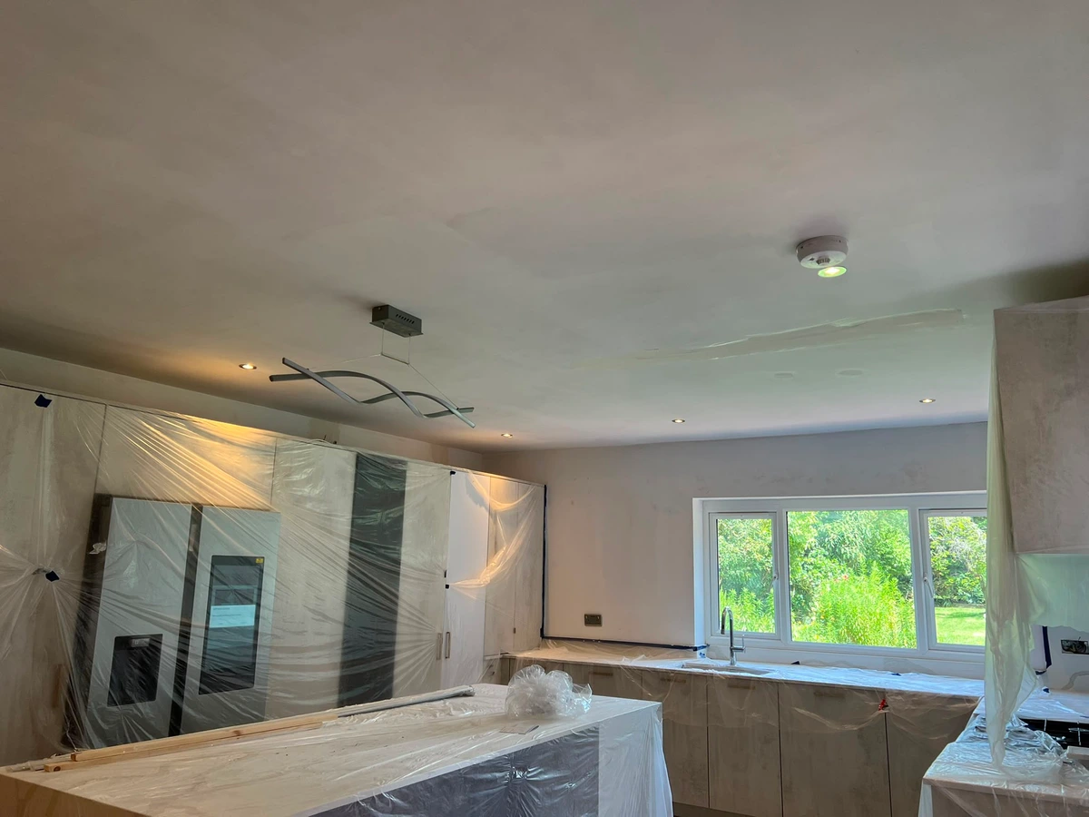 Downlights and a smoke alarm in a newly plastered ceiling
