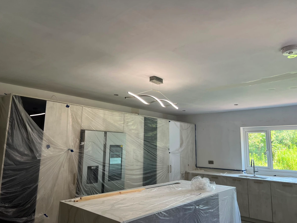 Linear pendant lit above a kitchen island during refurbishment