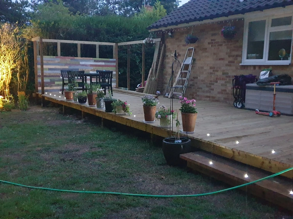 Recessed deck lights and garden uplighting lit at dusk