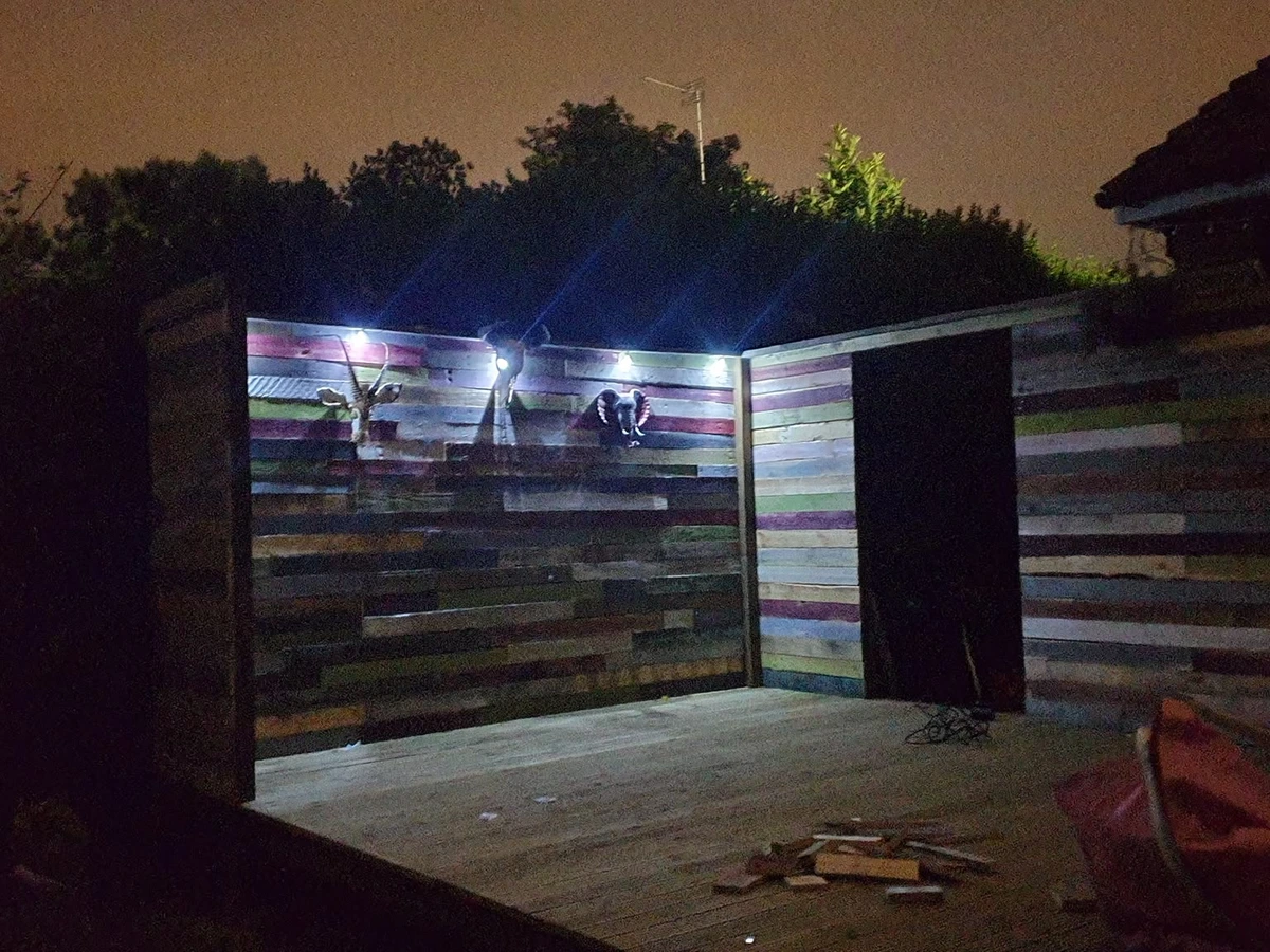 Outdoor spotlights lighting a decked seating area at night